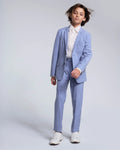 Child wearing a light blue suit with a white shirt on a plain background